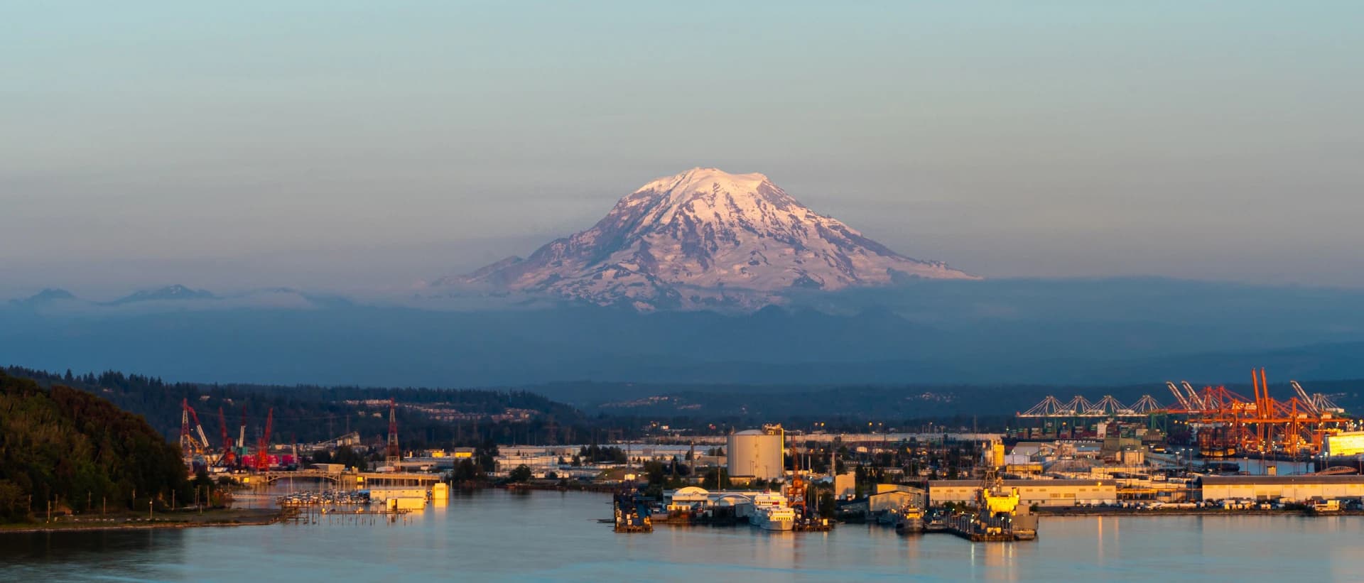 Port of Tacoma waterfront at dusk with Mount Rainier in the background