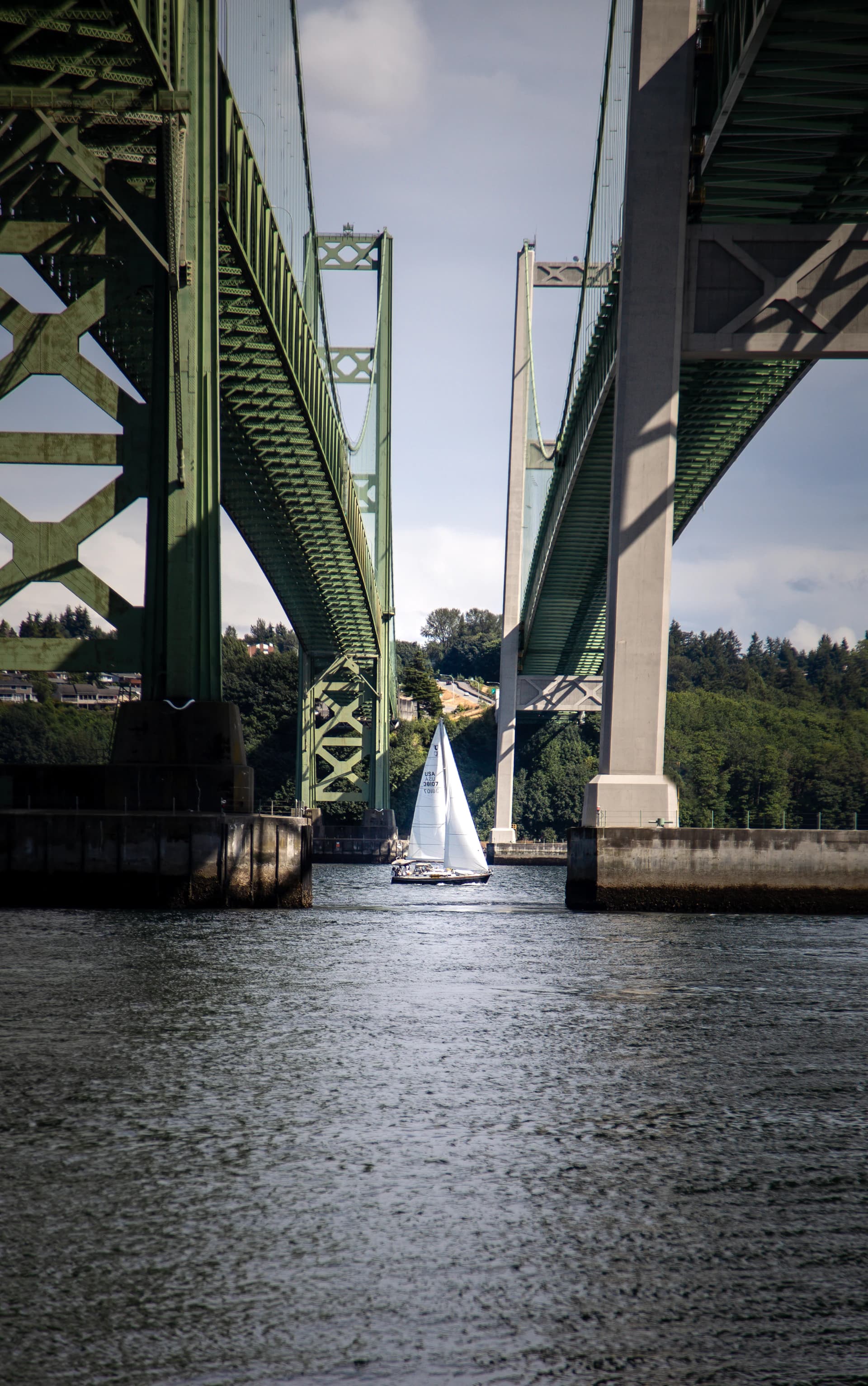 Sailboat passing under the Tacoma Narrows Bridge